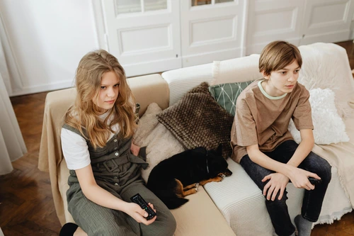 Two teens sitting on sofa with dog, child emotional needs and attention‑seeking