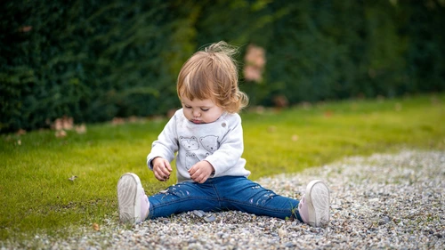 Toddler playing outdoors, seeking parental attention