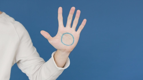 Hand with a blue circle drawn on the palm